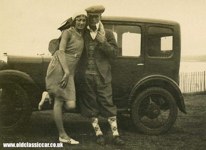 Lady and man stood alongside their Austin motor-car